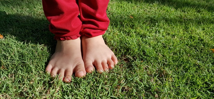 裸足で芝生の上を歩く